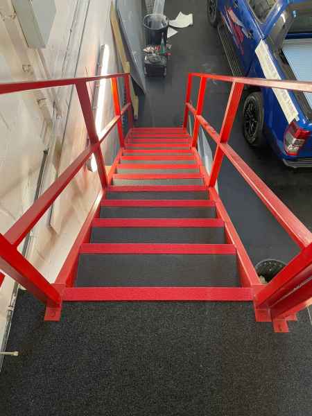 Red anti slip stair nosing on warehouse staircase