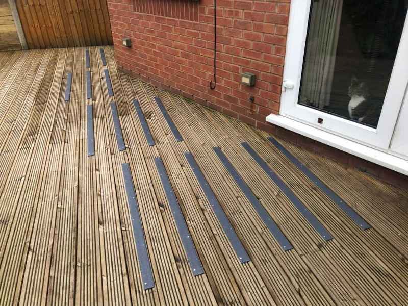 Dark Grey 50mm decking strips on garden decking with cat badger