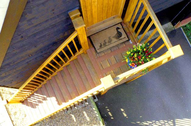 Wooden staircase flat entrance, made safer with grp strips.