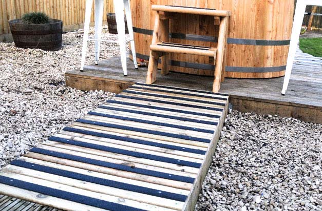 Garden hot tub with anti-slip decking strip path.