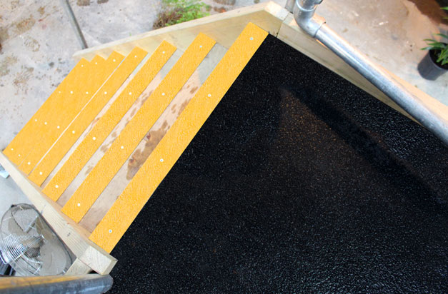 Slippery timber platforms made safe with floor sheets and stair nosing.