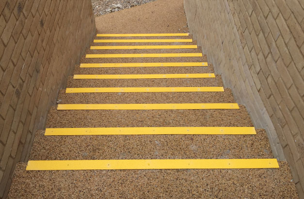 Anti slip stair nosing laid on a resin bound surface.