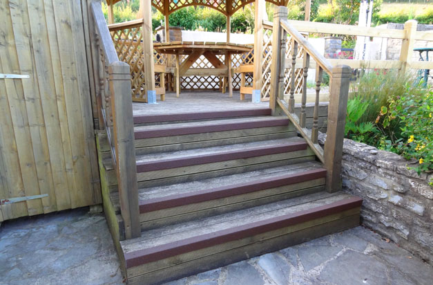 Slippery wooden steps with brown anti slip stair nosing.