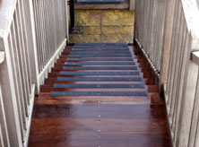 Stair nosing stair installation with black nosings on slippery wood surface.