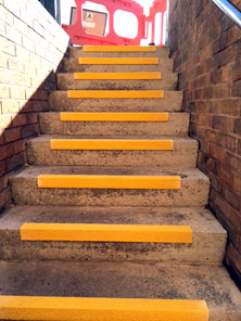 Stair nosing installation for shopping centre. Yellow nosings for stairway.